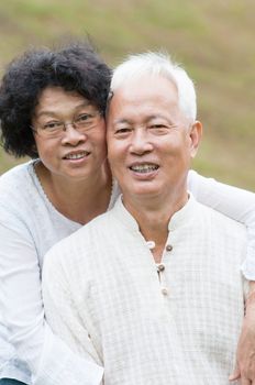 Portrait of elderly Asian couple relaxing at outdoor park.