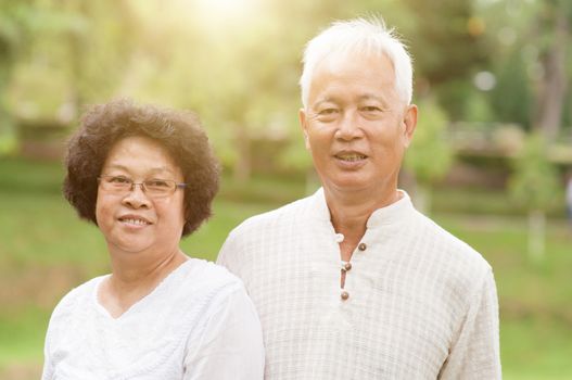 Happy Asian old couple smiling at outdoor park. 