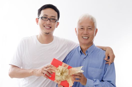 Asian old father and son hand holding a gift box and smiling,  standing isolated on white background.