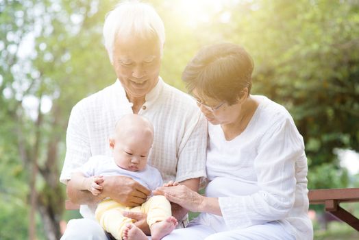 Senior couple with baby grandson, Asian grandparents with grandchild, life insurance concept.