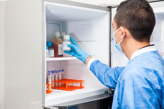 Young male scientist and laboratory freezer