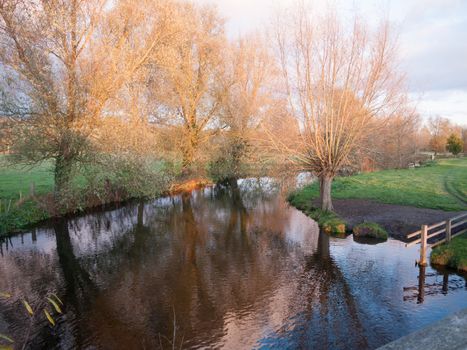 beautiful autumn bare branches no leaves countryside river sun set; essex; england; uk