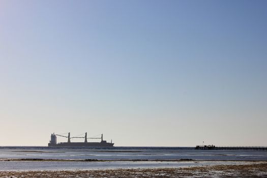 Sea ship sails along the shore at sun light
