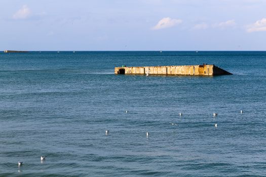 Ruins of harbor built by the Allies in Arromanches, Normandy, France