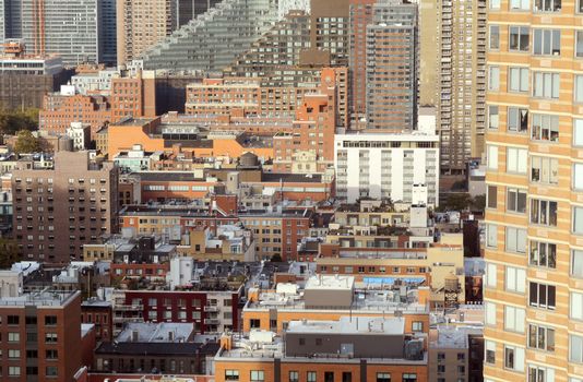 Cityscape of apartment and office buildings in Hell's Kitchen, New York City. Diverse architectural styles among tall skyscrapers.