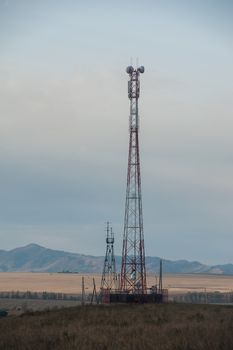 Telecommunications cell phone tower with antennas in a mountain location.