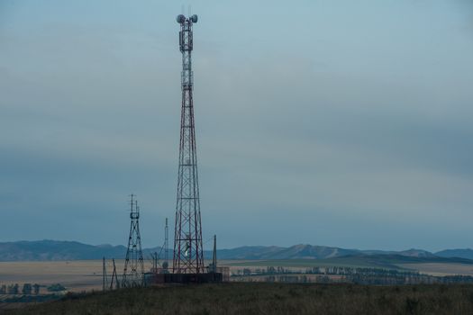 Telecommunications cell phone tower with antennas in a mountain location.