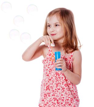 Happy Girl playing with soap bubbles isolated on white