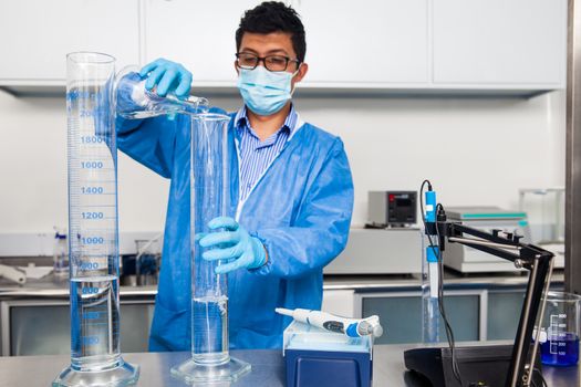 Young male scientist working at laboratory dressed in blue