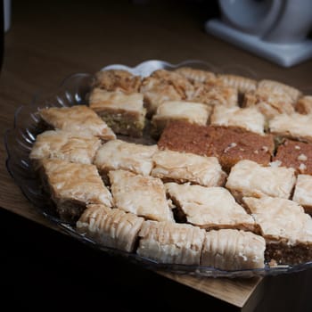 Tasty and sweet Turkish cookies on a transparent plate in room. Food concept.