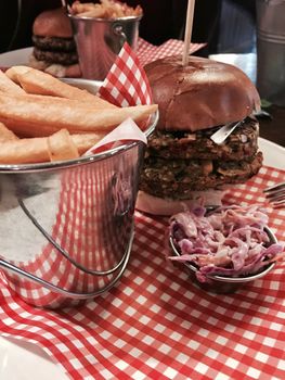 Big, fresh and delicious vegetable burger in restaurant on the white plate.