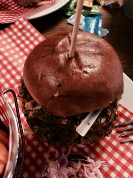 Big, fresh and delicious vegetable burger in restaurant on the white plate.