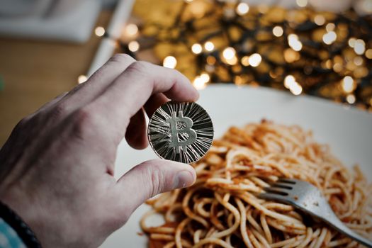 Digital currency physical metal bitcoin coin. Restaurant pasta concept.