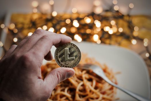 Digital currency physical metal gold litecoin coin. Italian food concept.