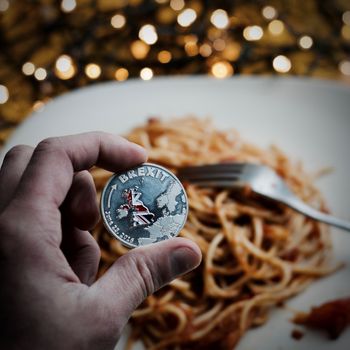 Silver physical brexit coin with british map. Italian pasta food concept.
