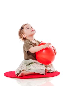 Baby holding balloon sitting on floor isolated on white