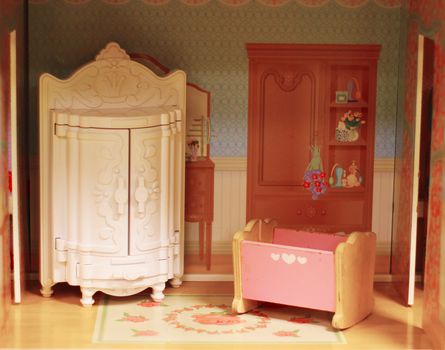 Vintage interior of baby dollhouse. Cute tiny doll room with closet and cradle