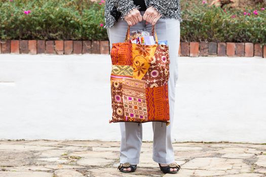 Woman carrying groceries in a reusable shopping bag