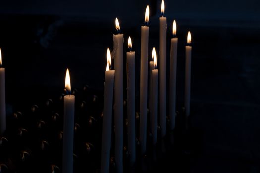 Detail of lit candles in the dark.