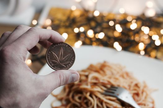 Brass marijuana coin with leaf. Italian pasta food concept.