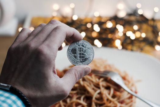 Digital currency physical metal bitcoin coin. Restaurant pasta concept.