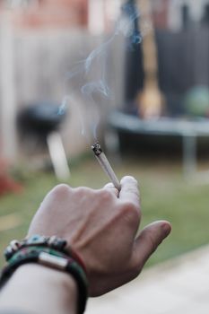 Small spliff in man hand. Marijuana smoking concept.