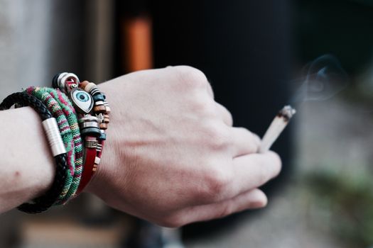 Small spliff in man hand. Marijuana smoking concept.