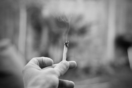 Small spliff in man hand. Marijuana smoking concept.