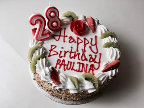 Tasty cake with happy birthday paulina inscription. Cake with strawberry and kiwi.