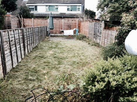 Fresh cut grass in the garden. Small garden and green umbrella.