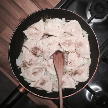 Food concept. Fresh and delicious dumplings on black pan in the kitchen