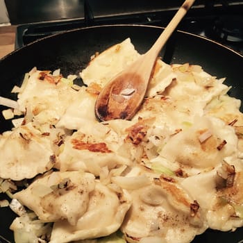 Food concept. Fresh and delicious dumplings on black pan in the kitchen