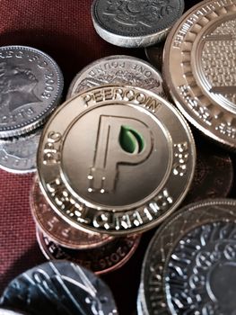 Digital currency physical gold peercoin coin near bitcoin coins. Finance concept.