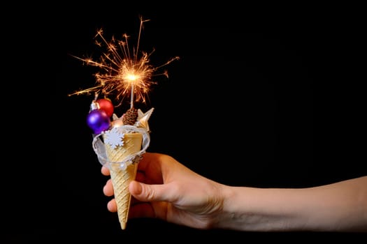 Ice cream cone and christmas decoration on black background