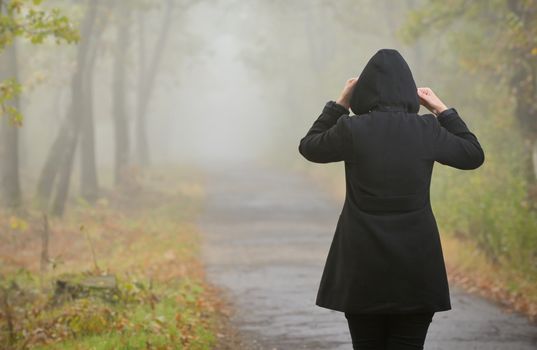 Woman In A Foggy Forest During Autumn