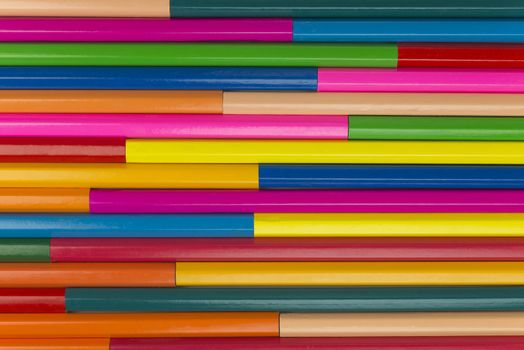 Collection of coloured pencils in a horizontal line pattern as background picture
