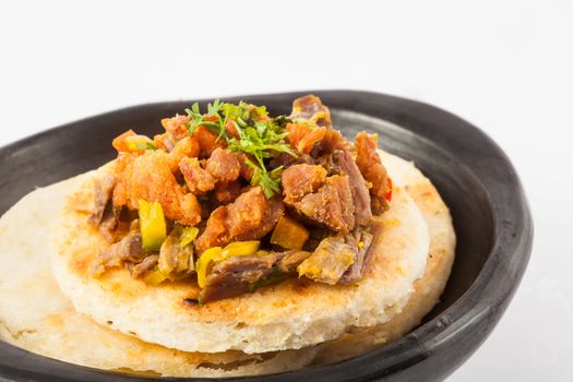Colombian arepa topped with shredded beef and pork rind