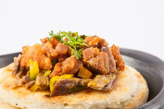 Colombian arepa topped with shredded beef and pork rind