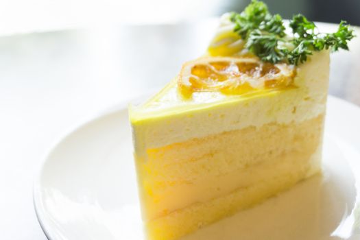 Closeup lemon cake on white plate in coffee shop for relax time concept, selective focus