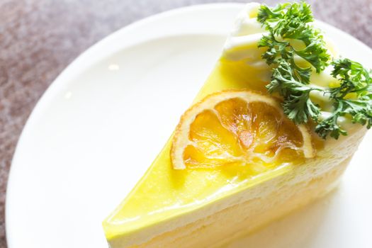 Closeup lemon cake on white plate in coffee shop for relax time concept