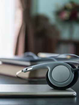 Headphones with book and mobile phone on wood table