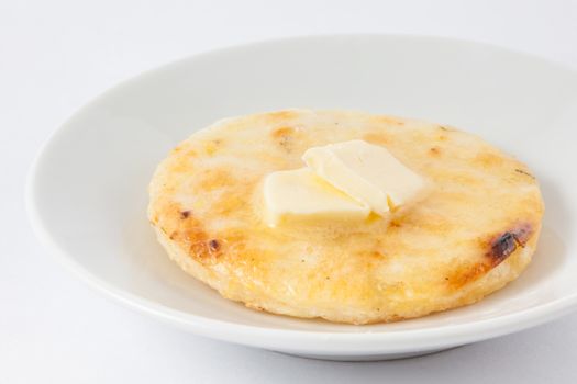 Traditional Colombian arepa topped with melted butter