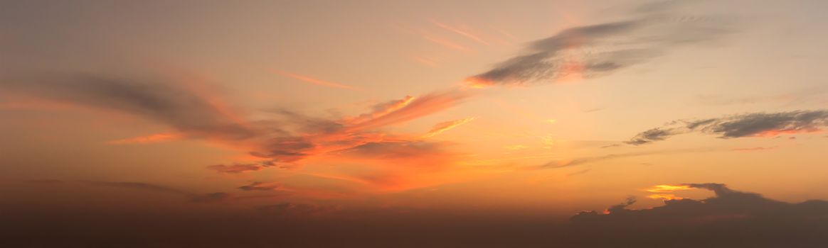 Panoramic orenge fluffy clouds in the twighligth sky