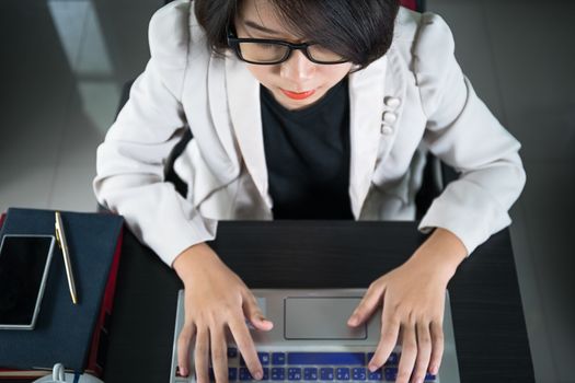 Young asian woman short hair in smart casual wear working on laptop in home office