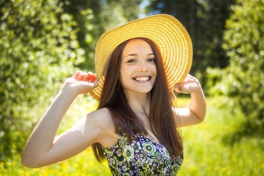 beautiful young brunette woman on the meadow on a warm summer day