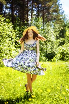 beautiful young brunette woman on the meadow on a warm summer day