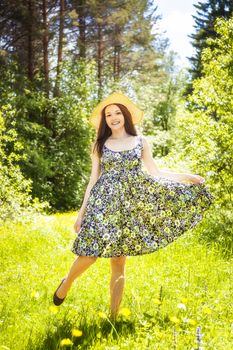 beautiful young brunette woman on the meadow on a warm summer day