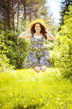 beautiful young brunette woman on the meadow on a warm summer day