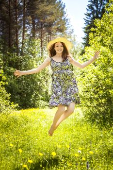 beautiful young brunette woman on the meadow on a warm summer day