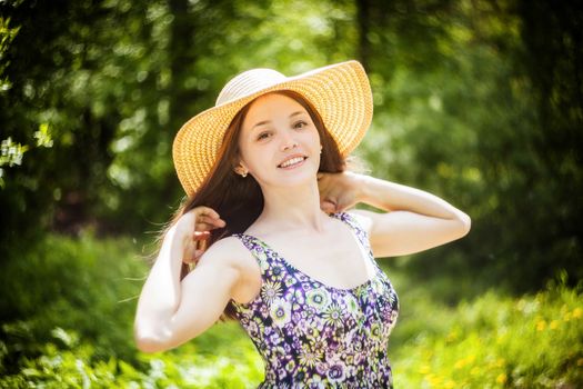 beautiful young brunette woman on the meadow on a warm summer day